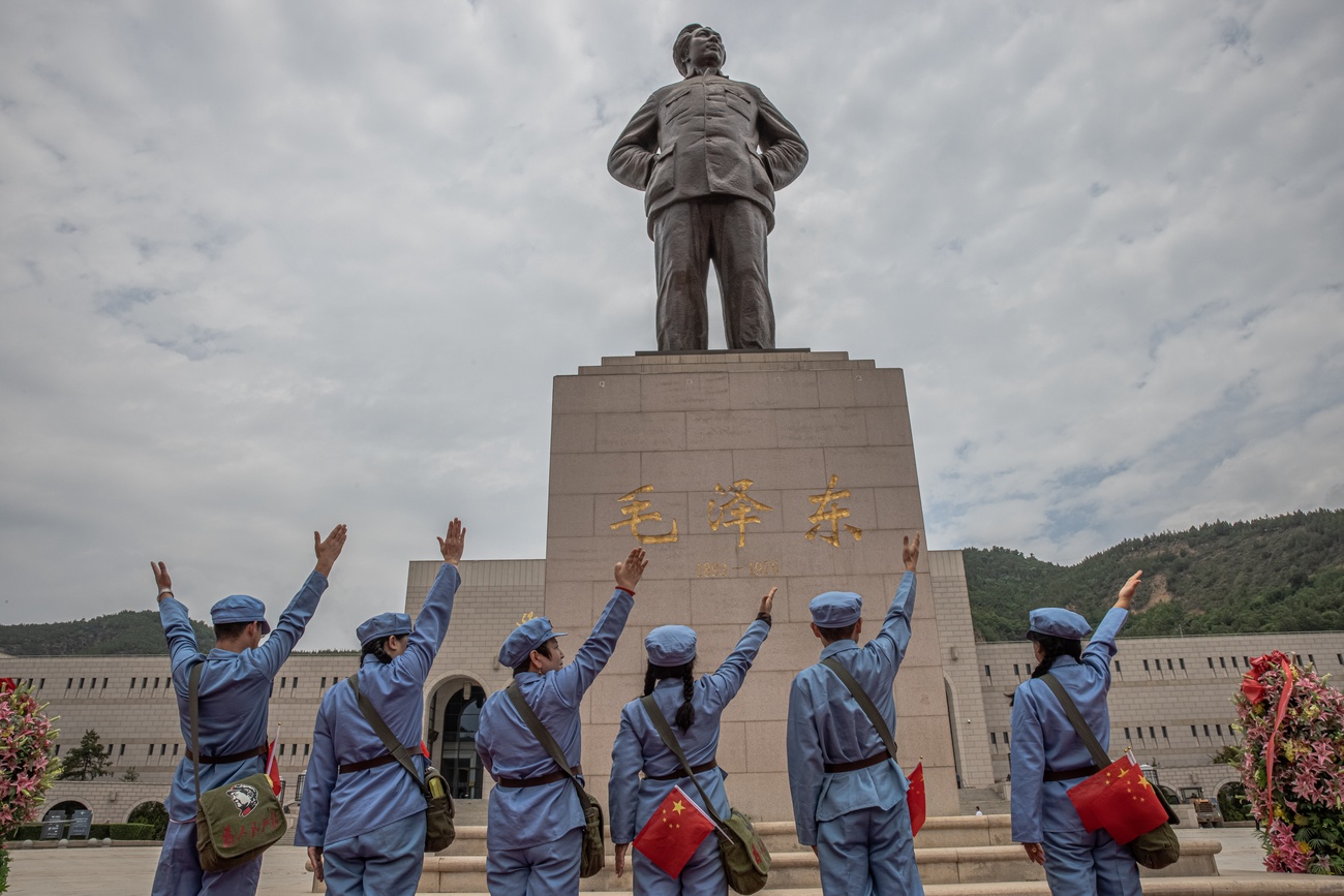 persone rendono omaggio alla statua di Mao Tse-Tung.