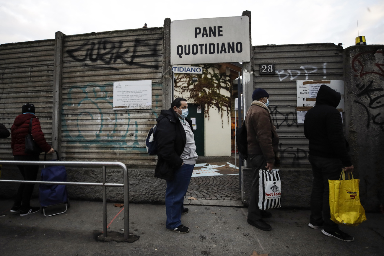 persone in fila per ricevere aiuti alimentari