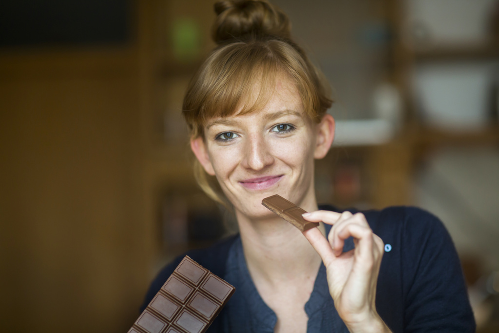 une jeune femme mange du chocolat