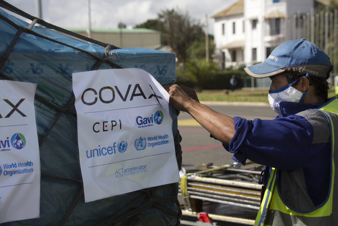 An airport worker checks the cargo of Covax COVID-19 vaccines