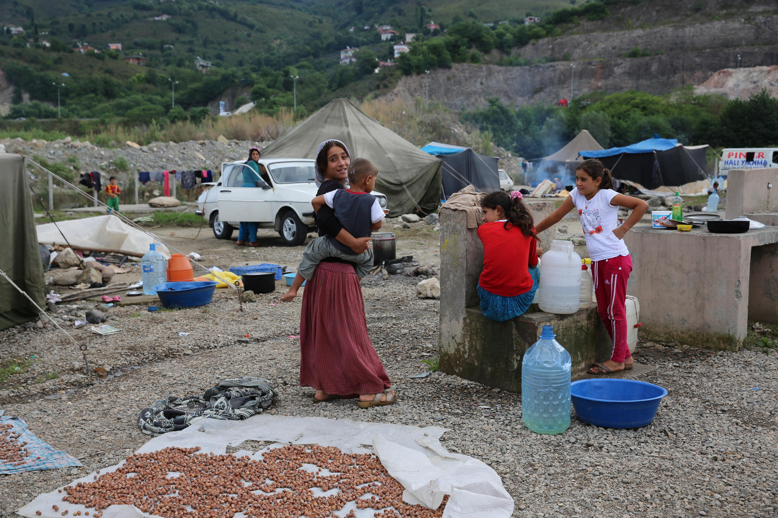 Children stand around a collection of hazelnuts in the Black Sea, Turekz