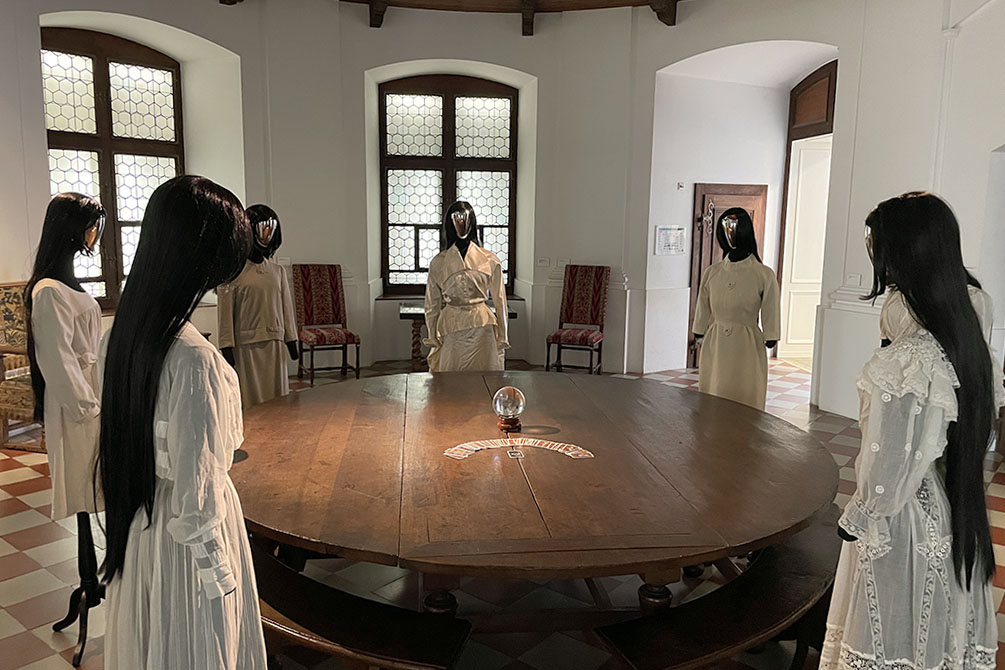 Models around an old table with cards and a crystal ball