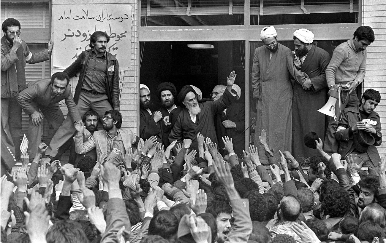 صورة بالأبيض والأسود لآية الله الخميني وهو يُحيي حشدا من أنصاره من مقر إقامته في ضواحي العاصمة الإيرانية طهران