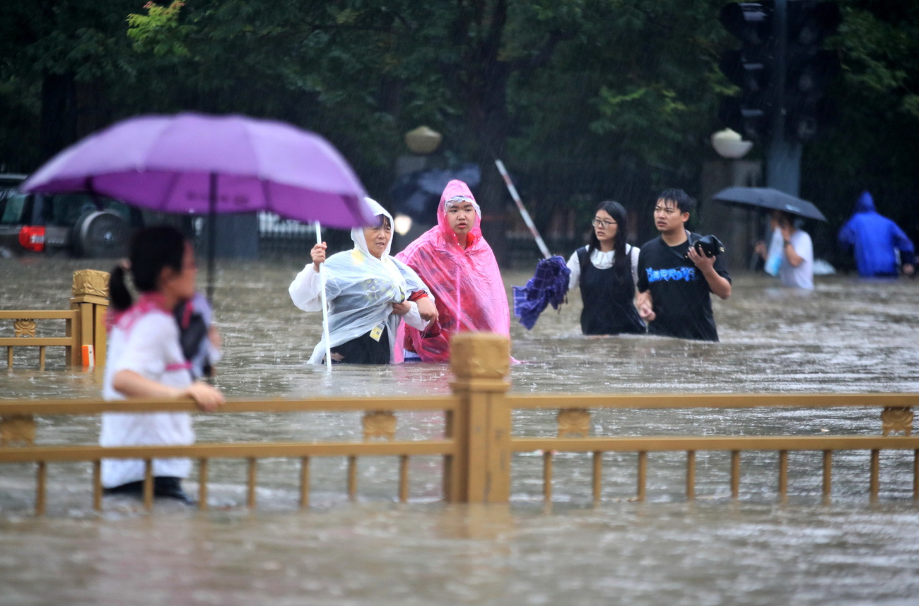 Persone che camminano per le strade con l acqua fino ai fianchi.