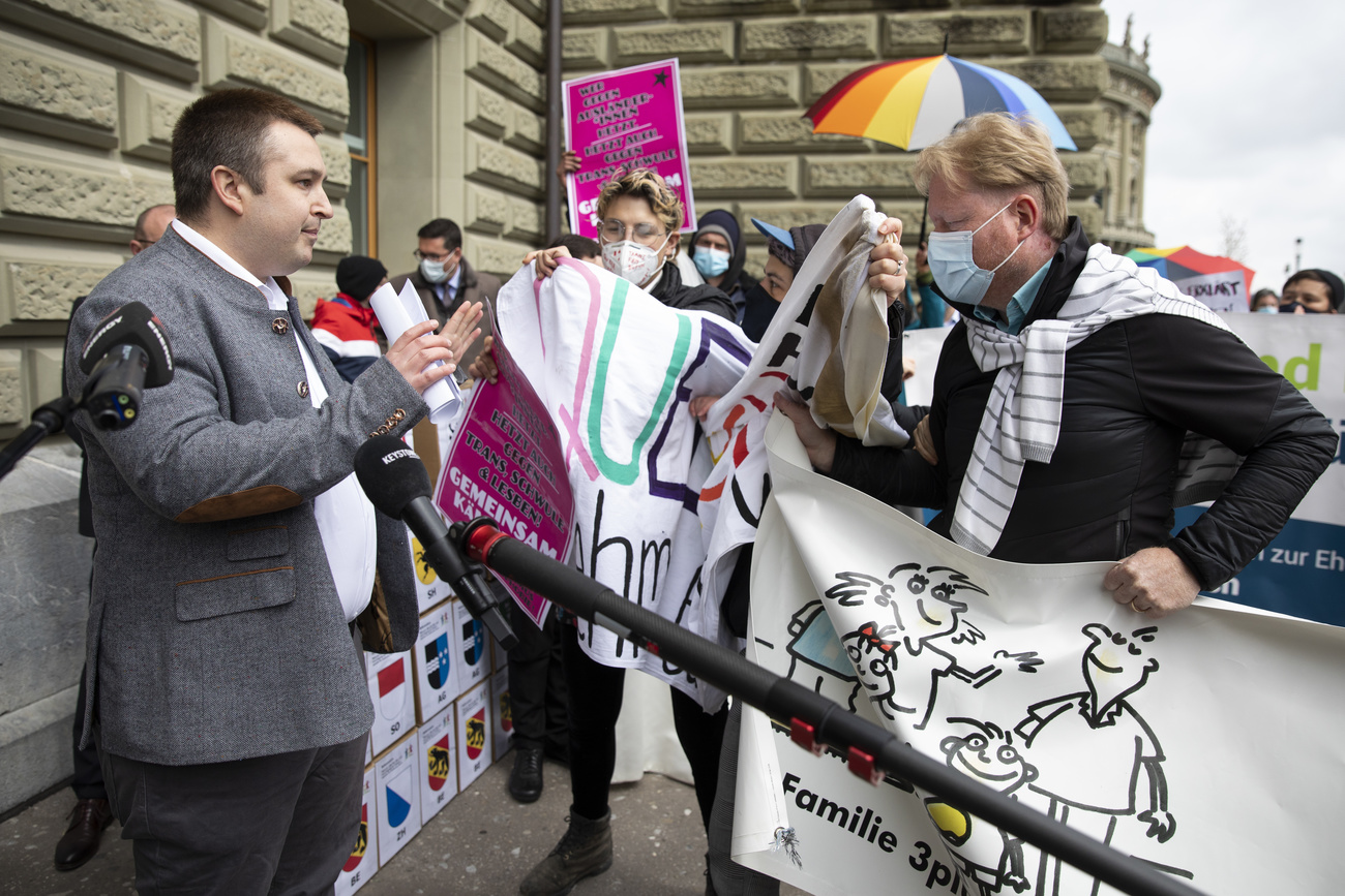 رجل يُناقش مجموعة من النشطاء يرفعون شعارات ولافتات