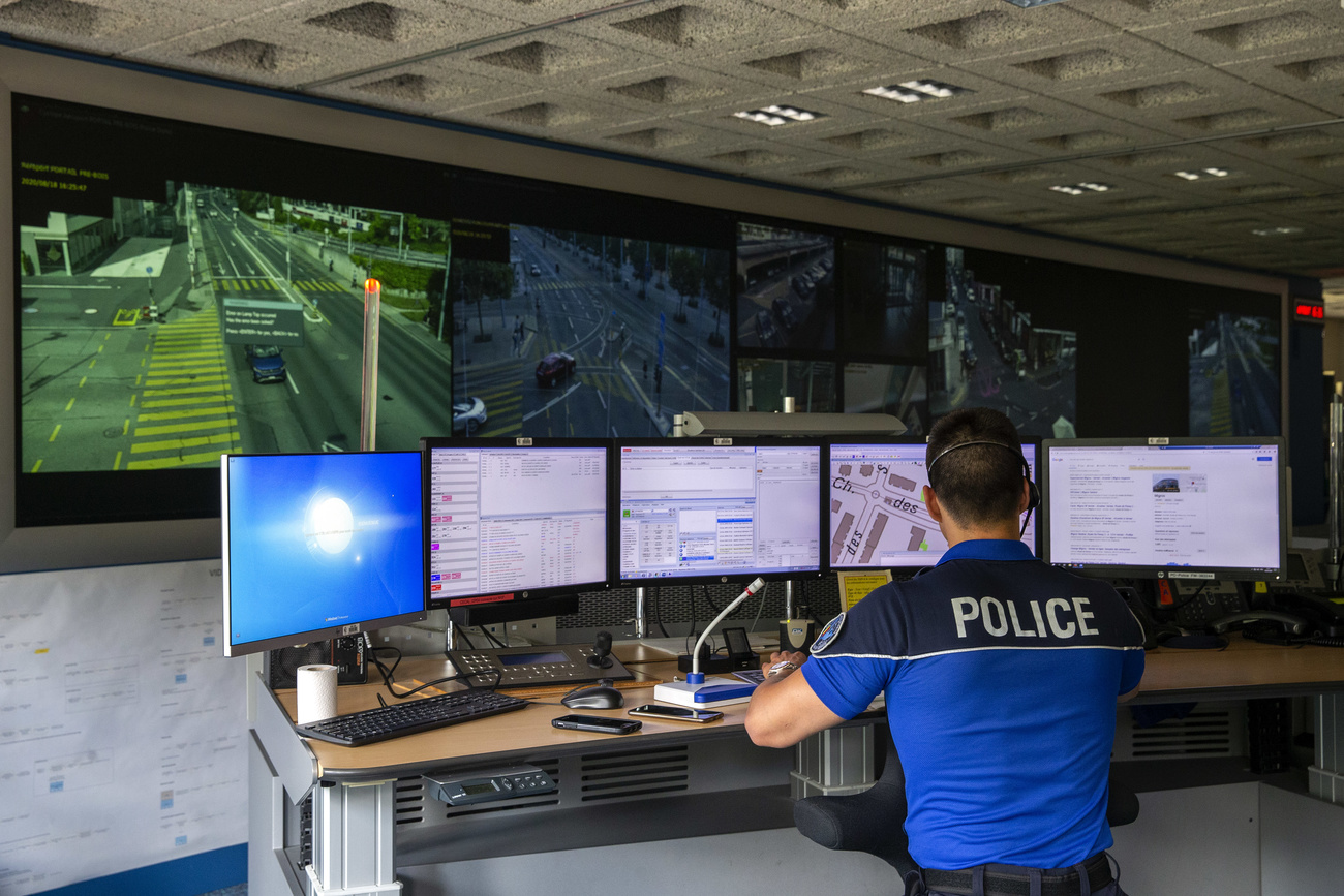 Policeman sitting in front of computer screens in a traffic control centre