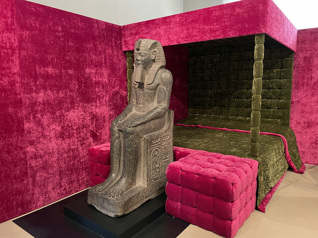 Egyptian statue ornating a velvet bed