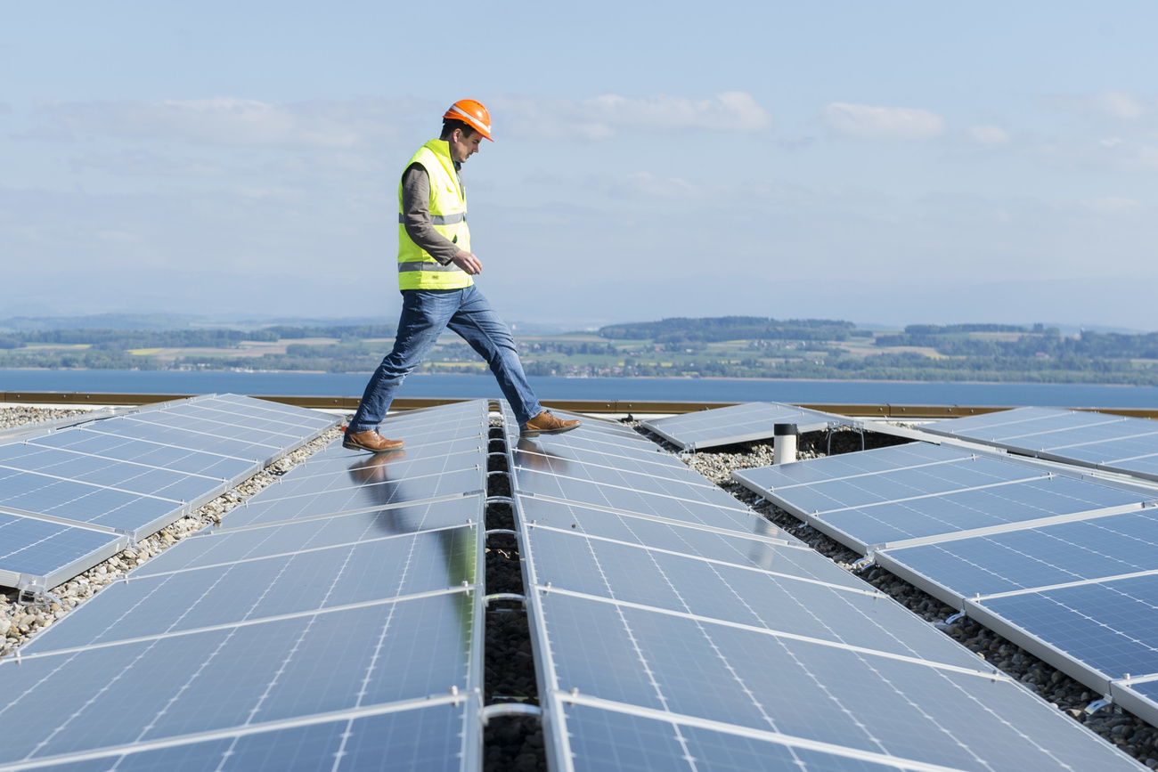 Construction Worker Walking Across Solar Panels