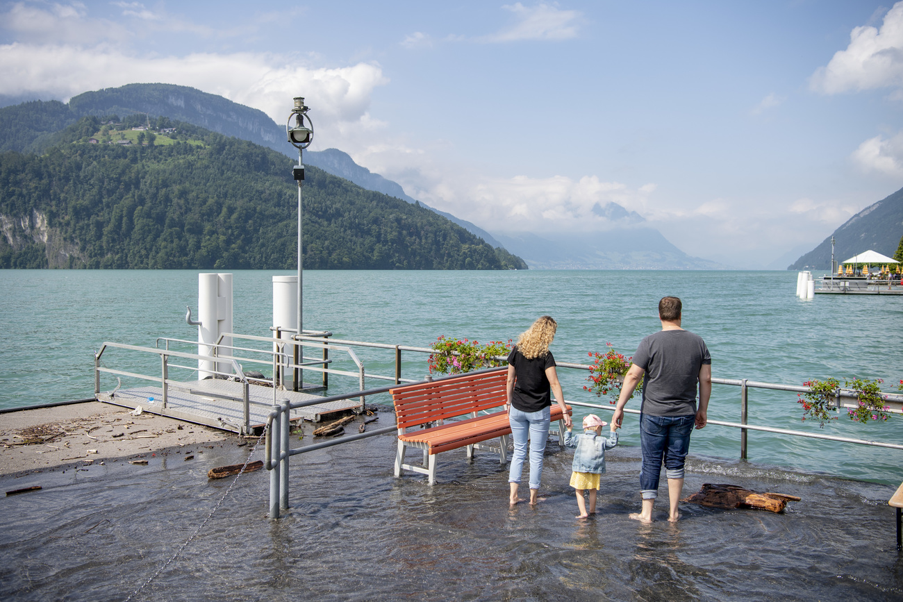 Familie watet im Hochwasser an einem See