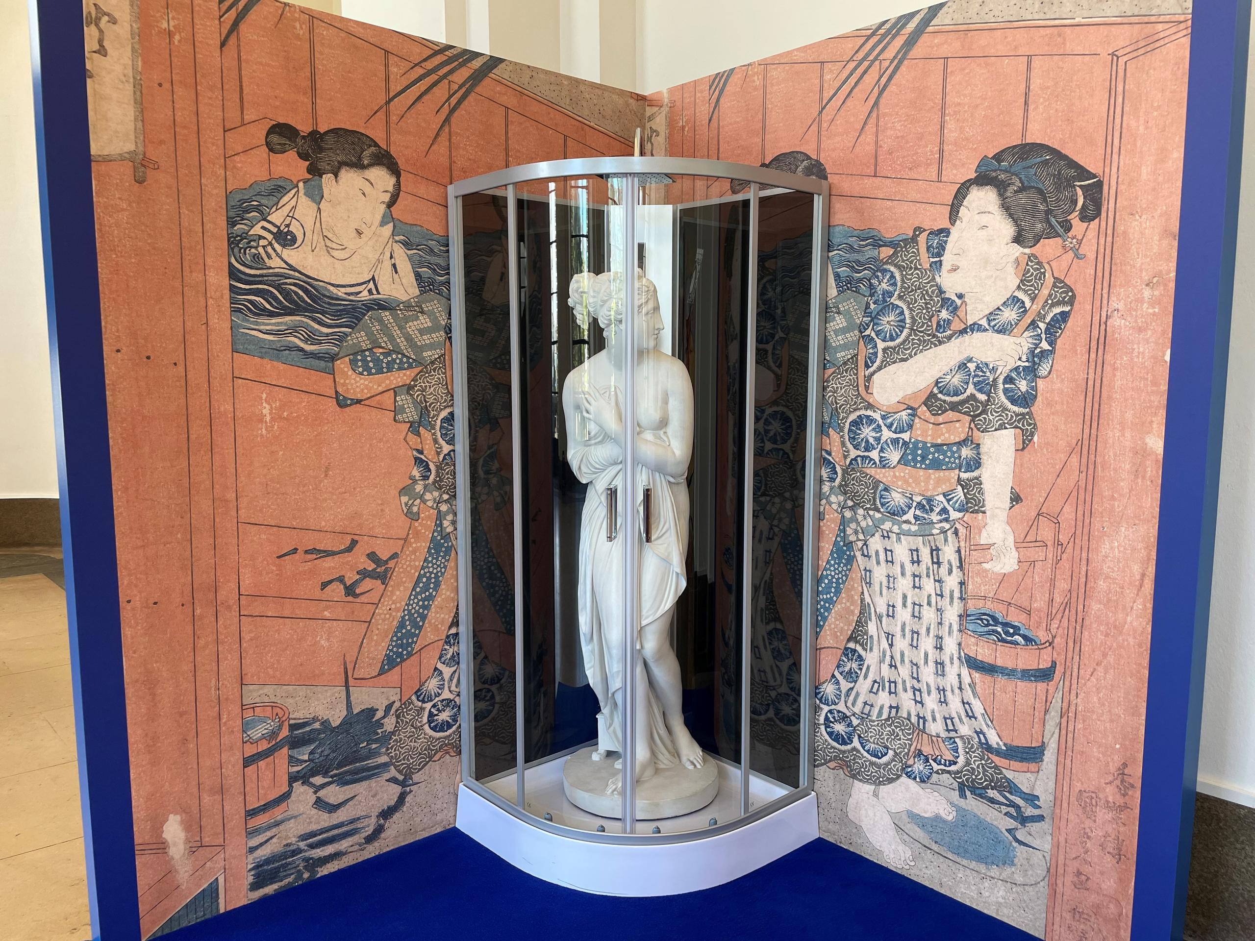 Greek statue inside a shower box ornated with a Japanese print outside