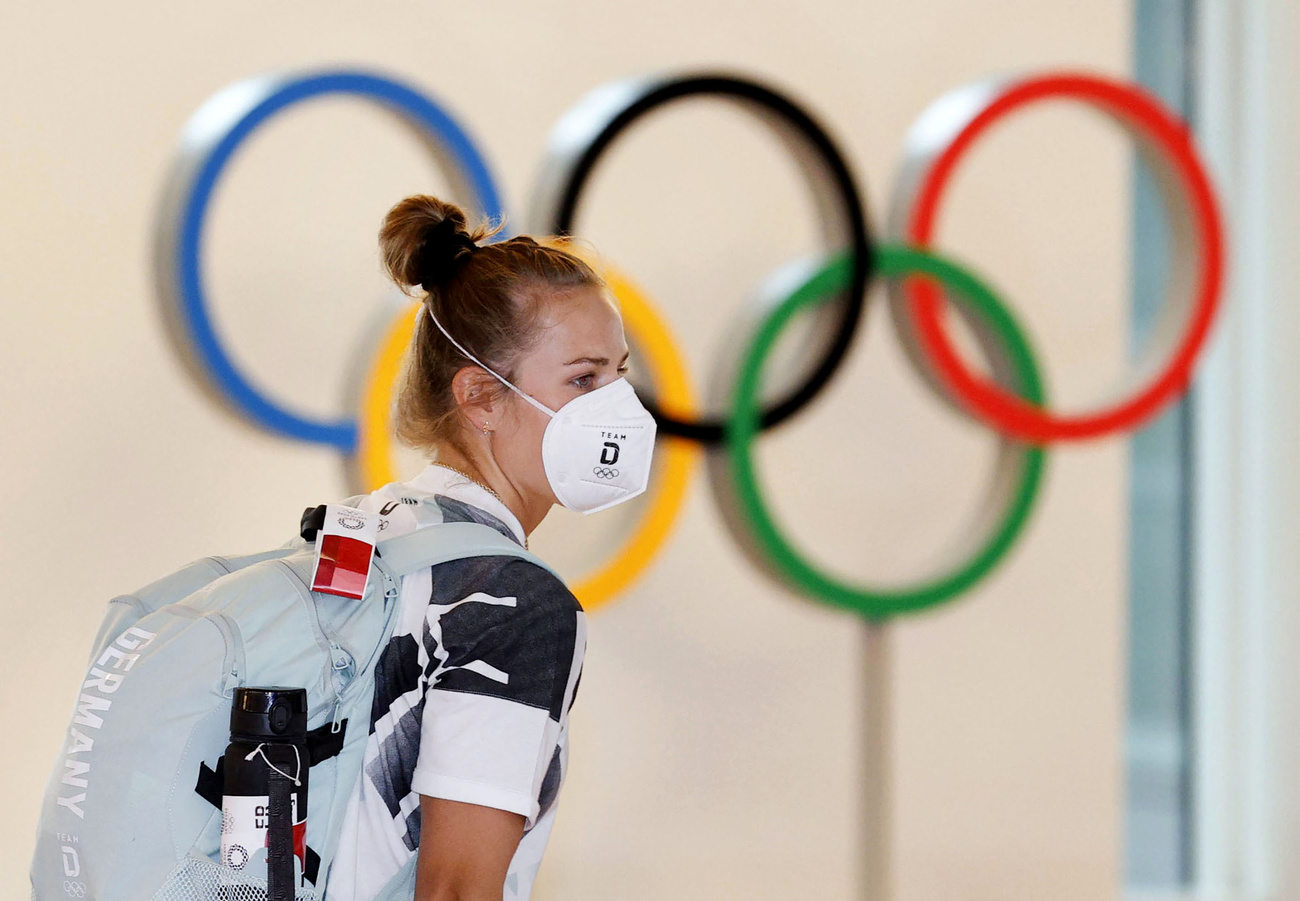 atleta con mascherina in sottofondo gli anelli olimpico