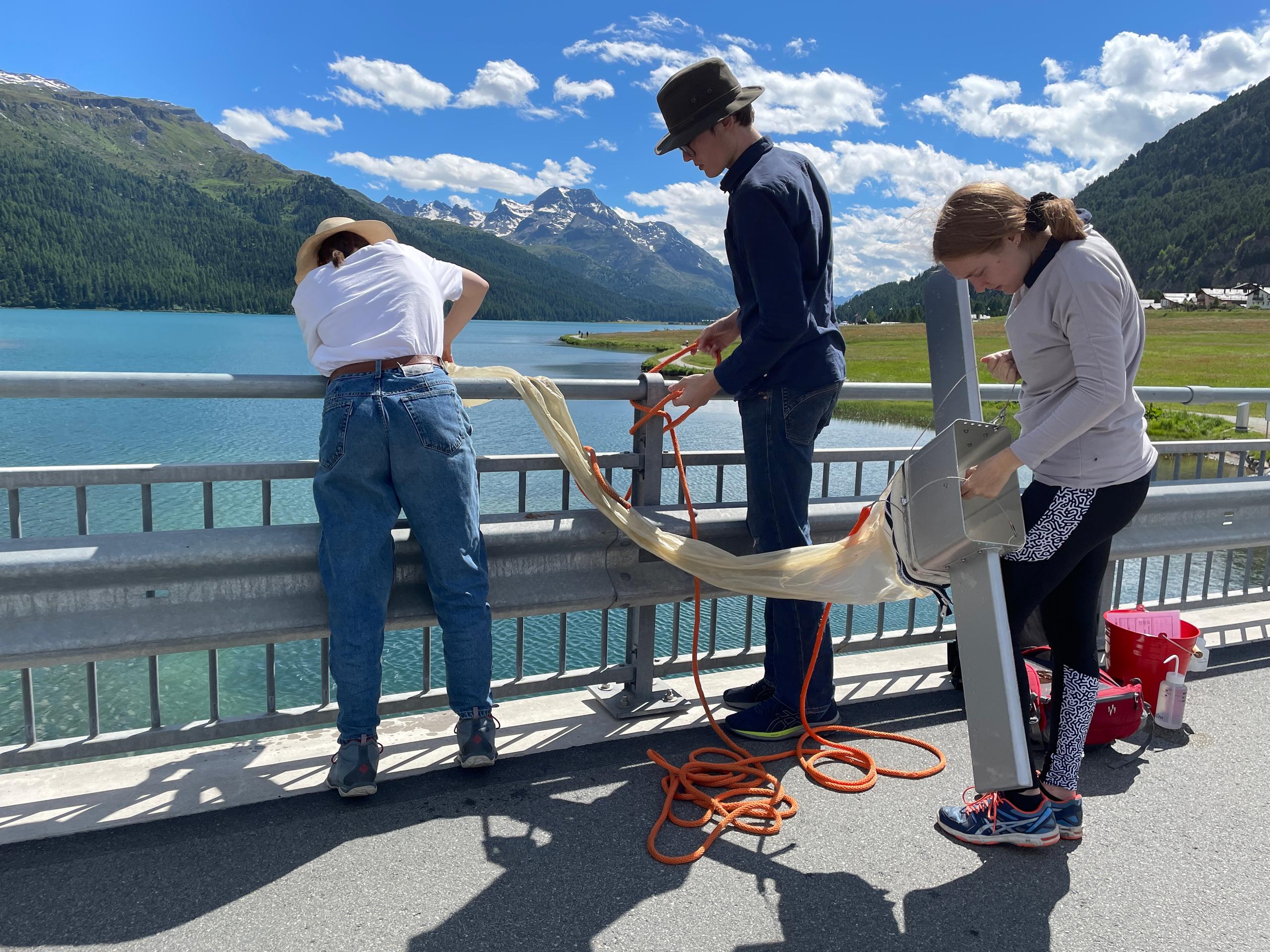 tre studenti preparano la rete a strascico su un ponte