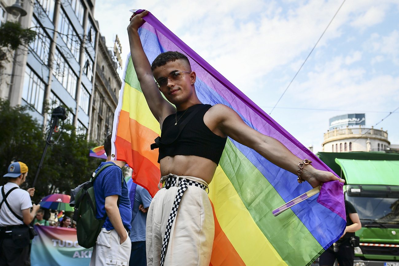 uomo gay con bandiera arcobaleno