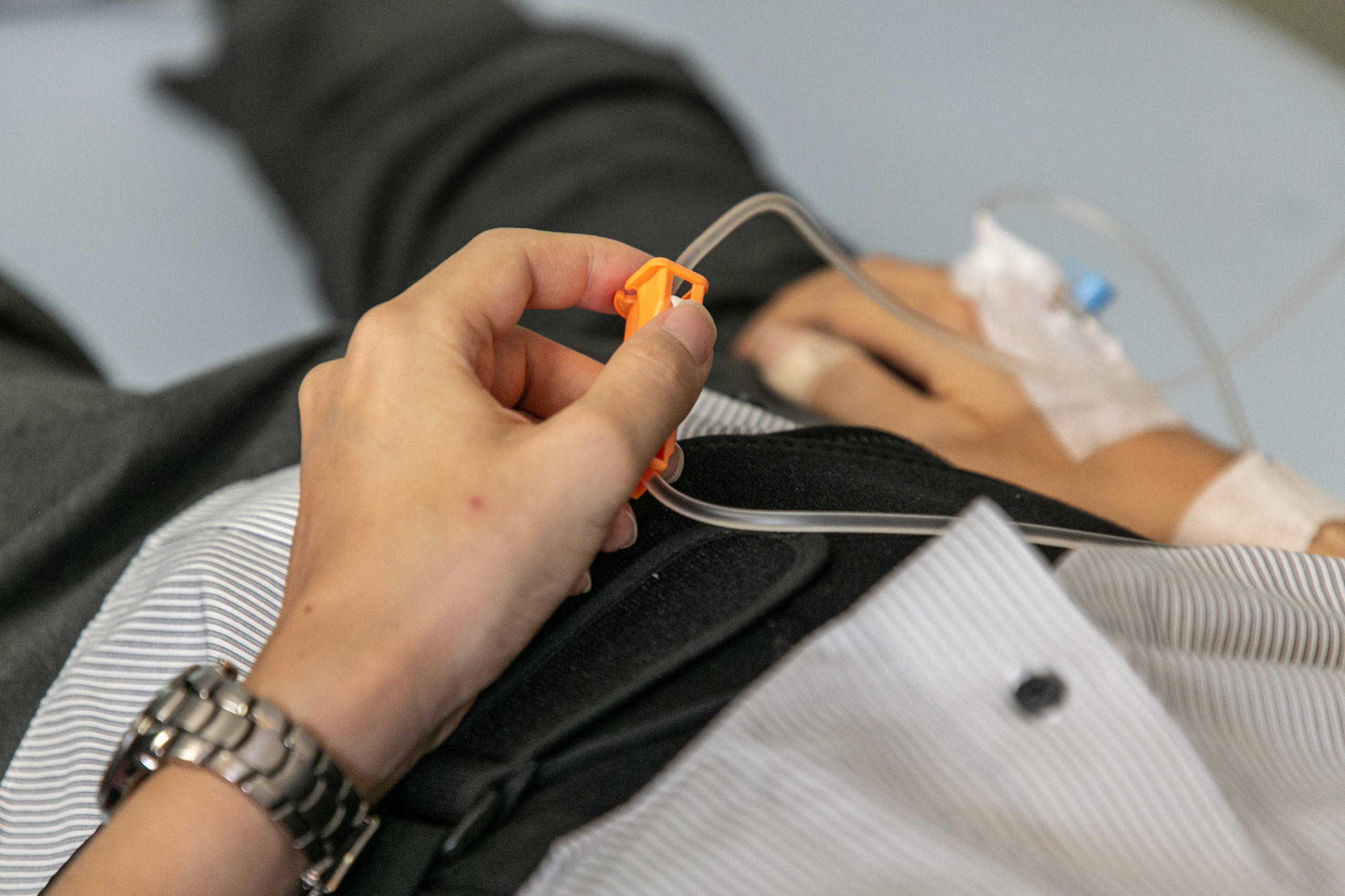 An ill man holding an IV drip in preparation for his assisted suicide