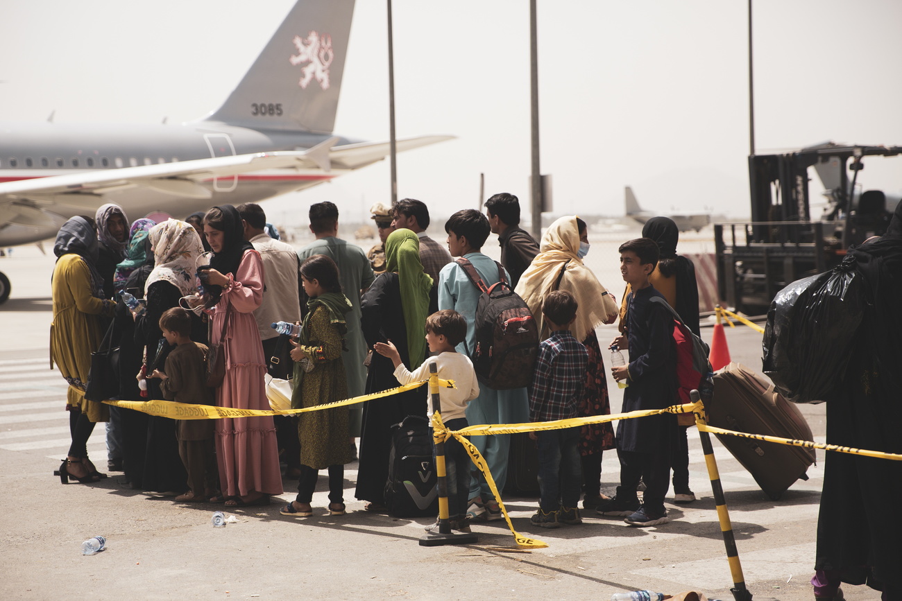 Civilians prepare to board a plane during an evacuation at Kabul Airport.