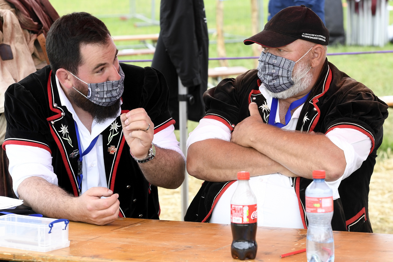 Two men in traditional clothes wearing masks