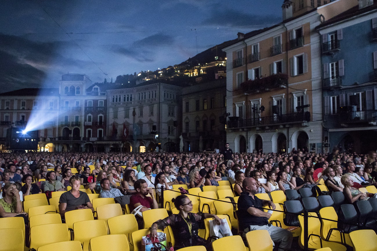 spettatori assistono a una proiezione cinematografica in piazza
