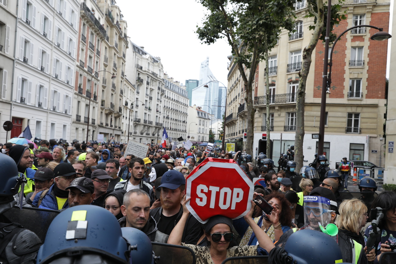 Una folla per le vie di Parigi contro il certificato sanitario imposto dal governo.