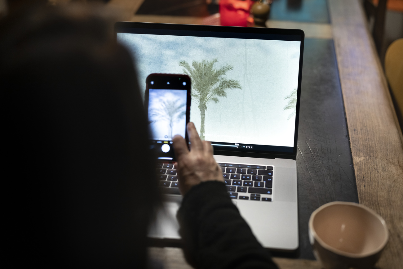 donna fotografa schermo del pc con telefonino
