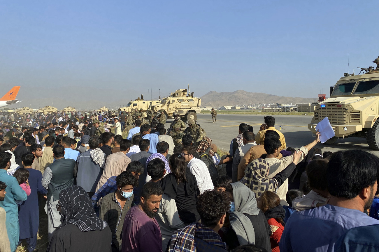 Crowd of people at Kabul airport guarded by US soldiers