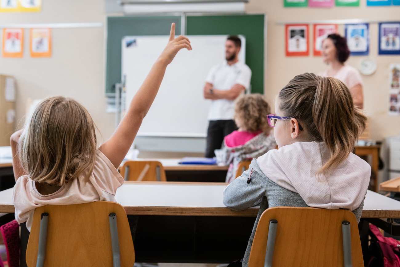 Un allieva delle elementari di Chiasso alza la mano per rispondere alla maestra.
