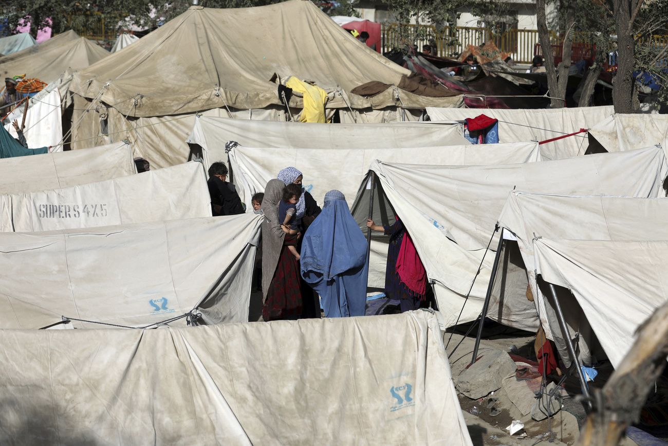 نساء يرتدين البرقع وسط خيام في مخيم للاجئين الأفغان