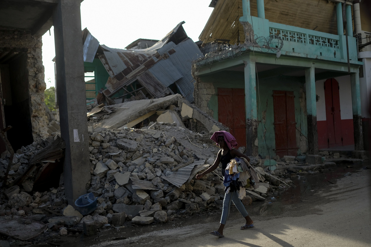 Person walks by rubble in Haiti