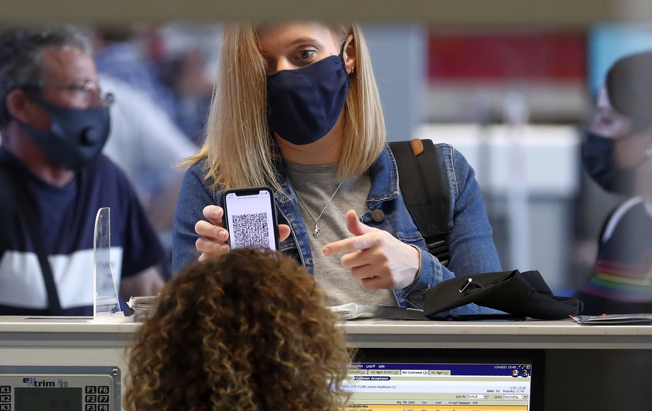 Una ragazza mostra sul suo telefonino il certificato Covid