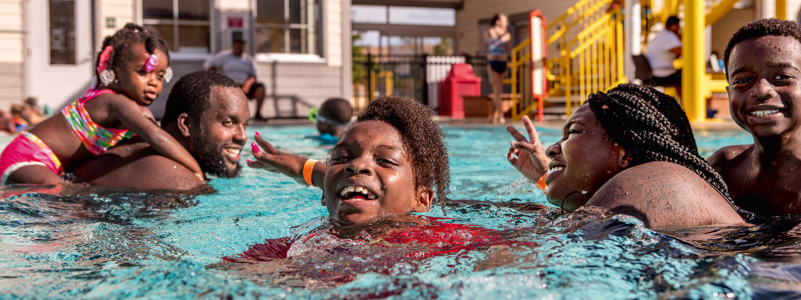 Famille noire dans une piscine.