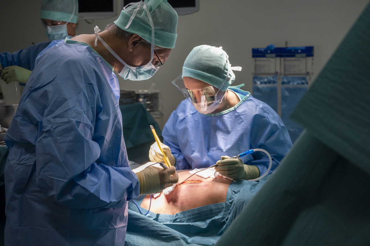 Médico y enfermera en operación de transplante de órgano