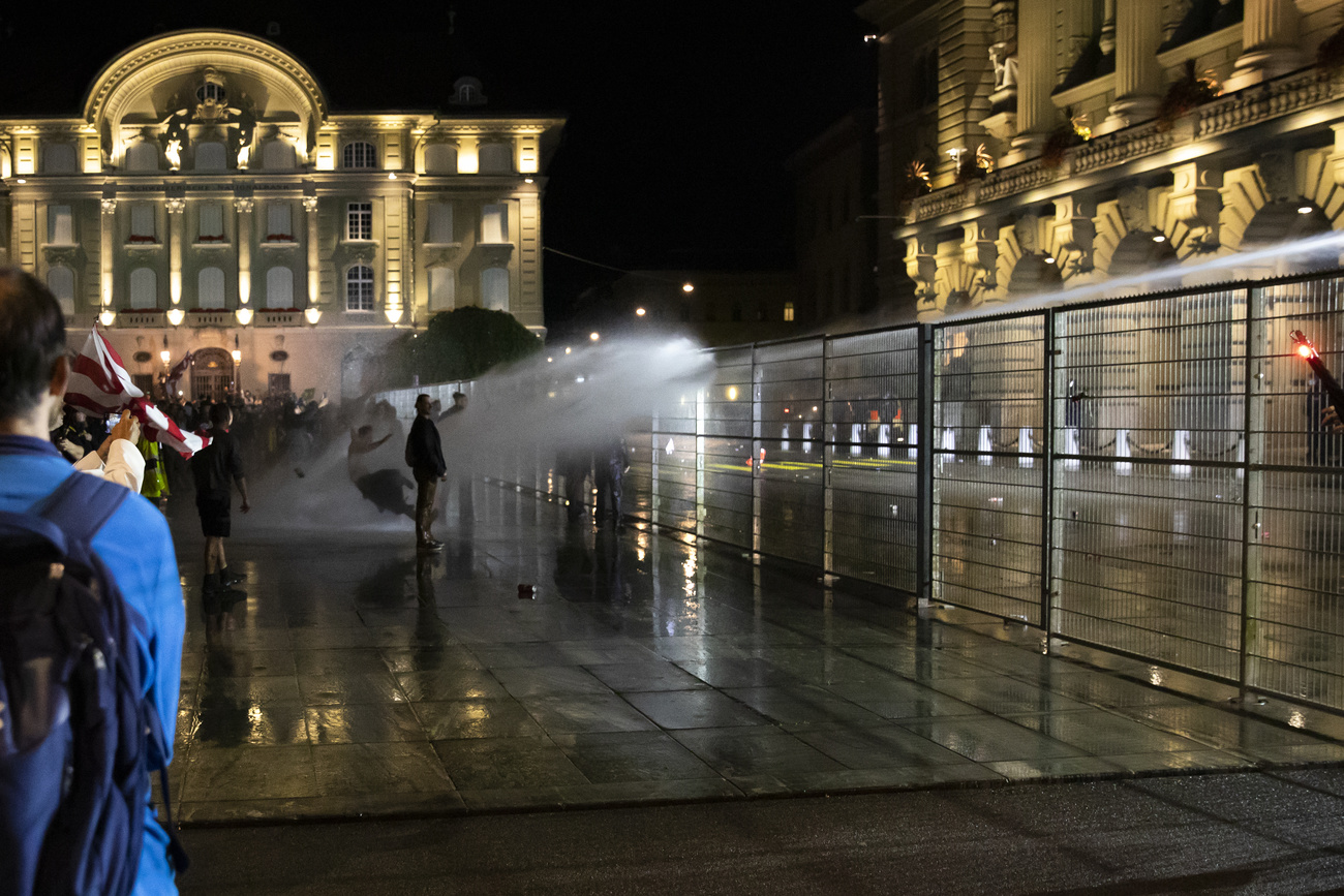 警方在议会广场上使用高压水龙。