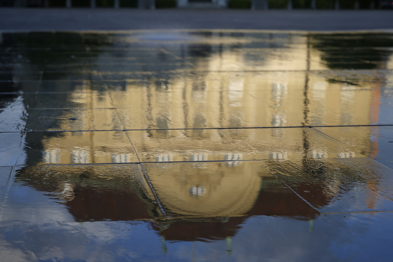 Schweizerische Nationalbank spiegelt sich im Wasser des Brunnens auf dem Bundesplatz