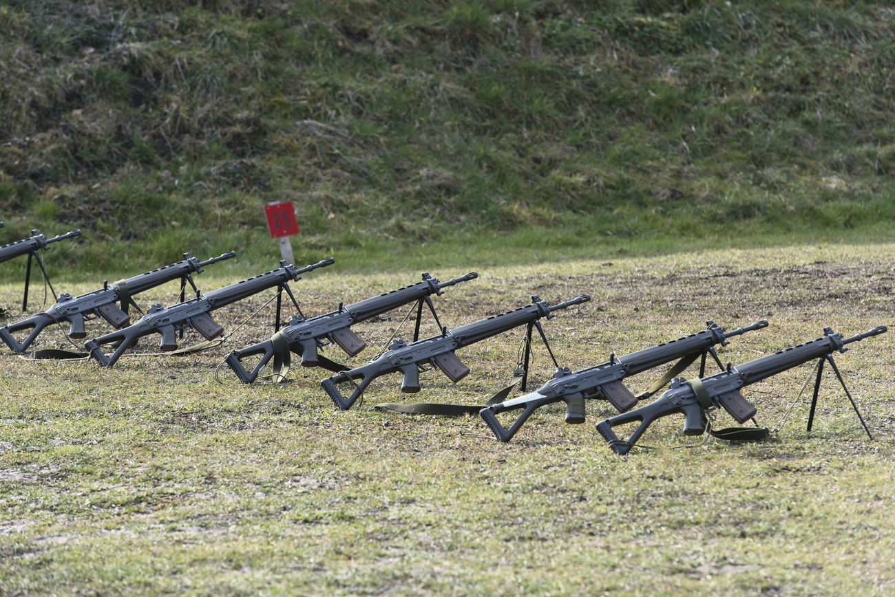 Army-issue rifles lined up in an outdoor shooting range