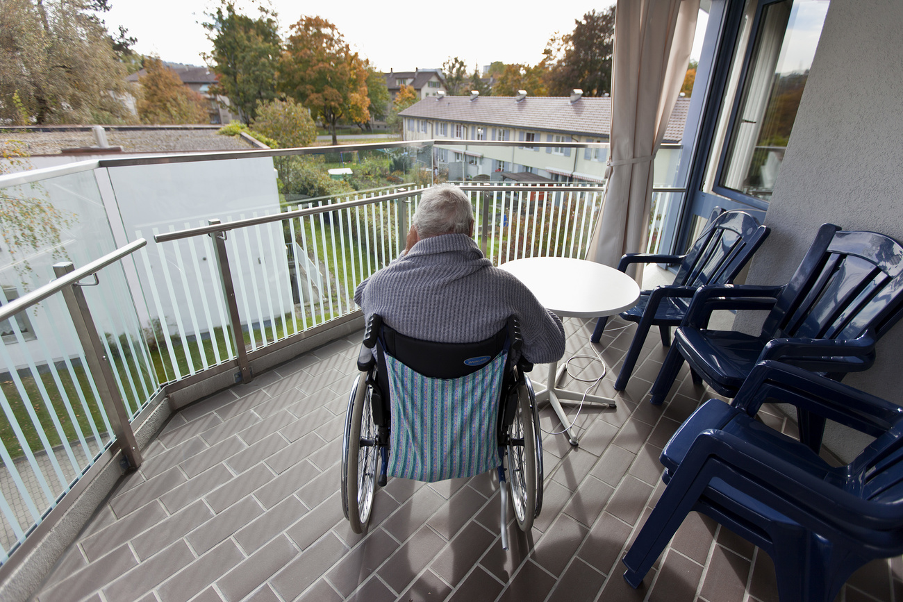 Un hombre mayor sentado en una silla de ruedas en un balcón