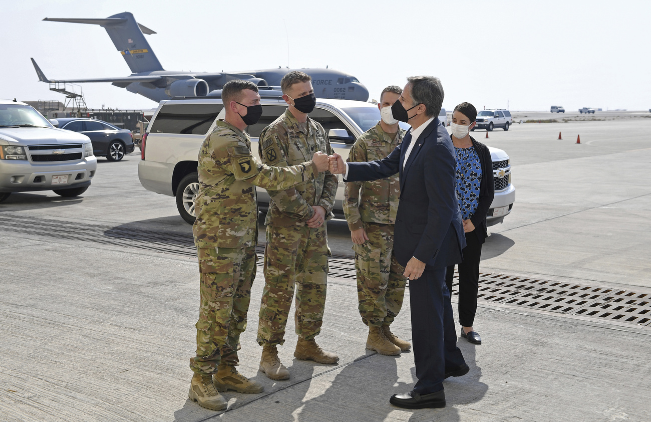 Antony Blinken saluta dei militari americani alla base militare di Doha nel Qatar.
