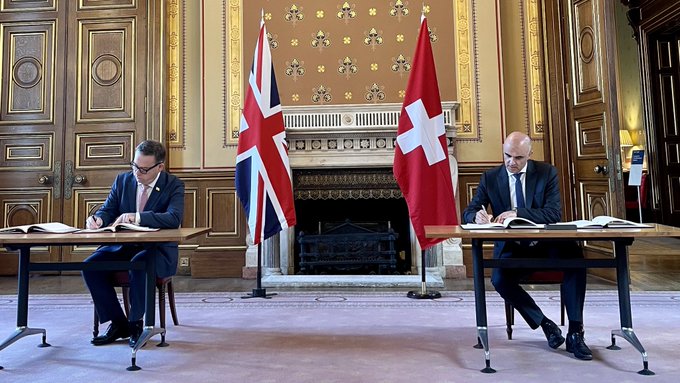Alain Berset signing the deal with British Foreign, Commonwealth and Development Office Minister, Nigel Adams.