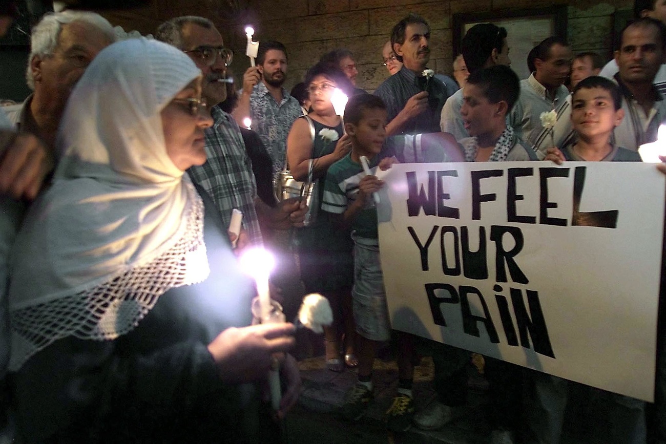 رجال ونساء مسيحيون ومسلمون يشاركون في وقفة احتجاجية بالشموع