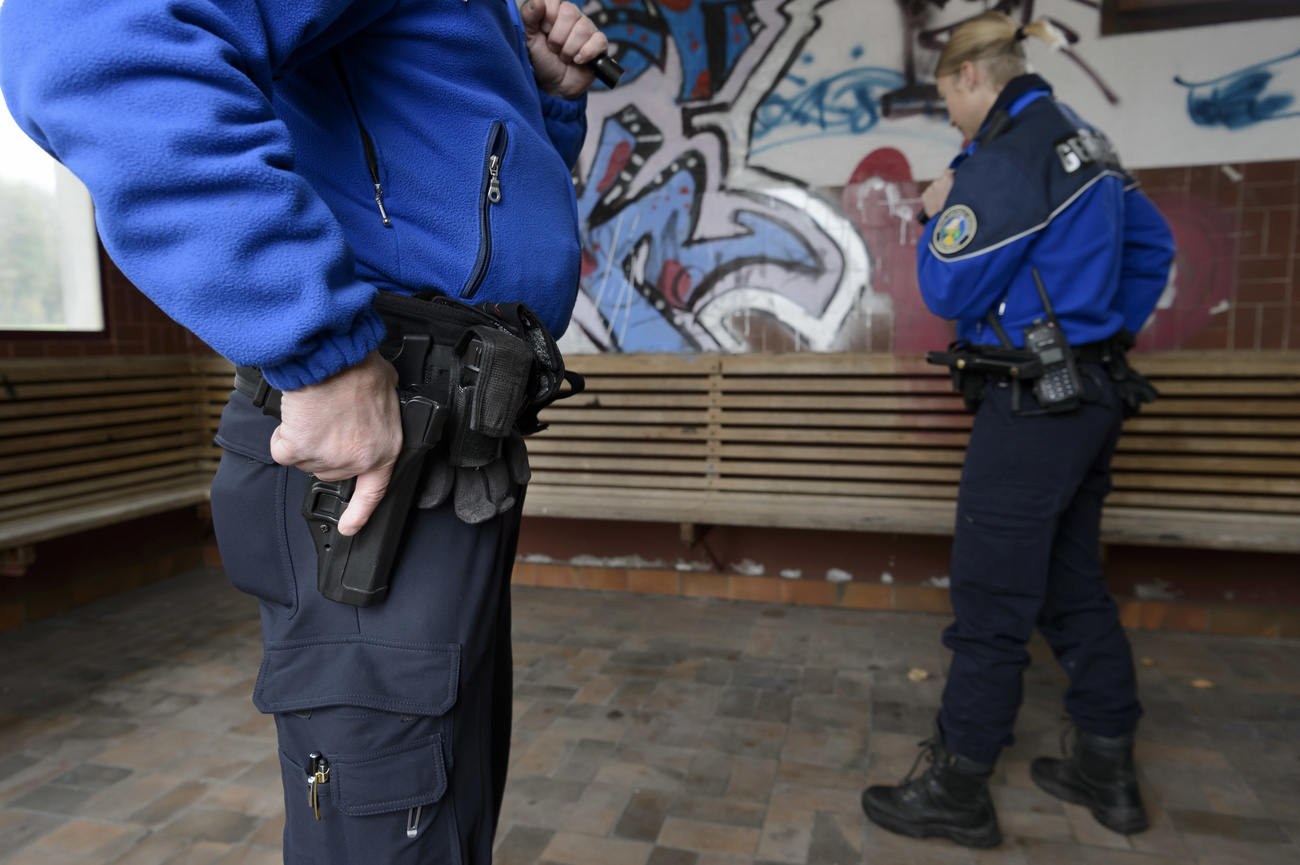 Un poliziotto sta estraendo la sua pistola dalla fondina.