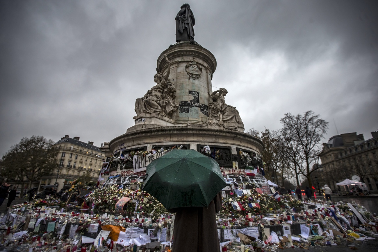 Passant mit Regenschirm vor Gedenkmal