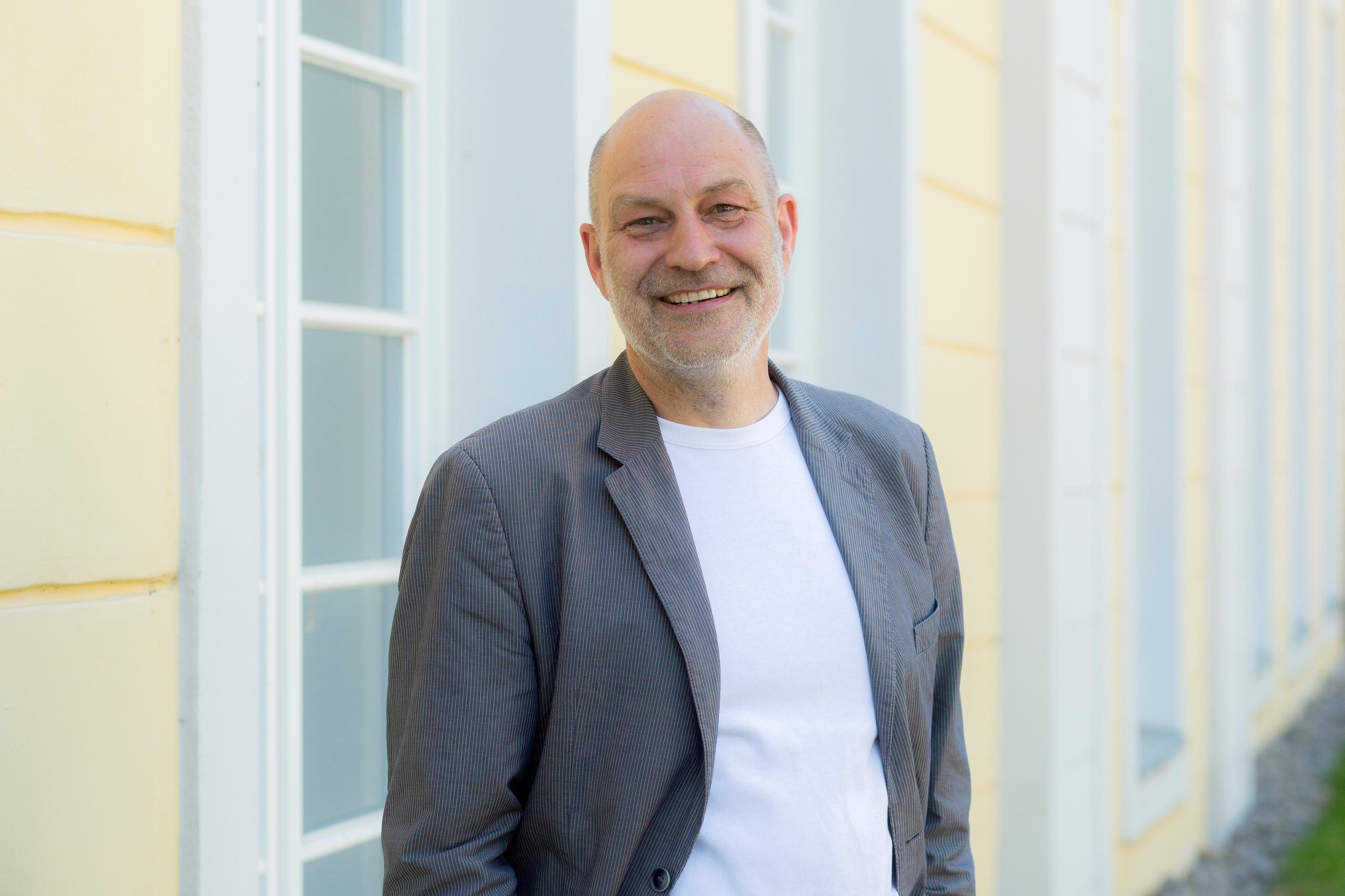 Lächelnder Mann vor einem grossen Gebäude