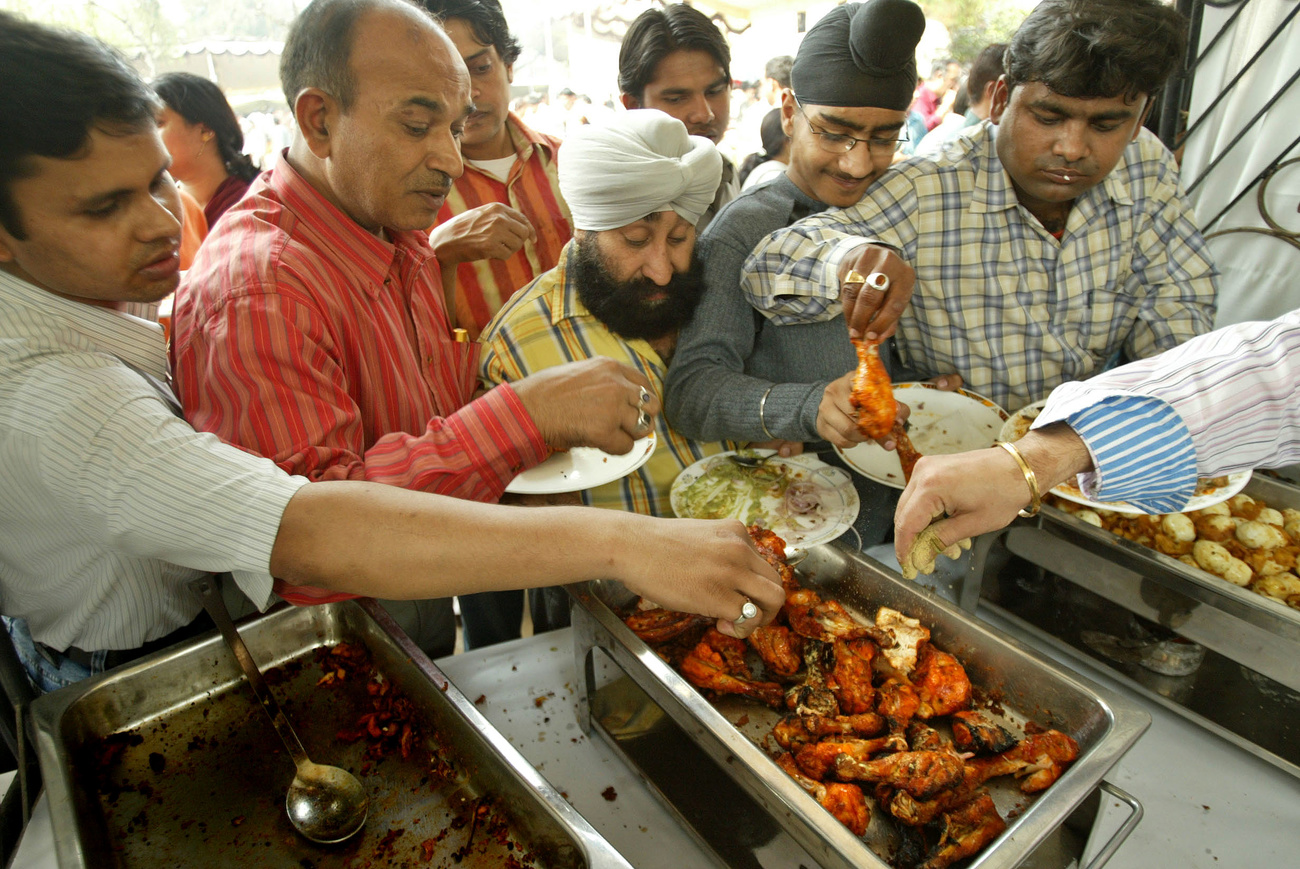 Persone si servono di carne di pollo