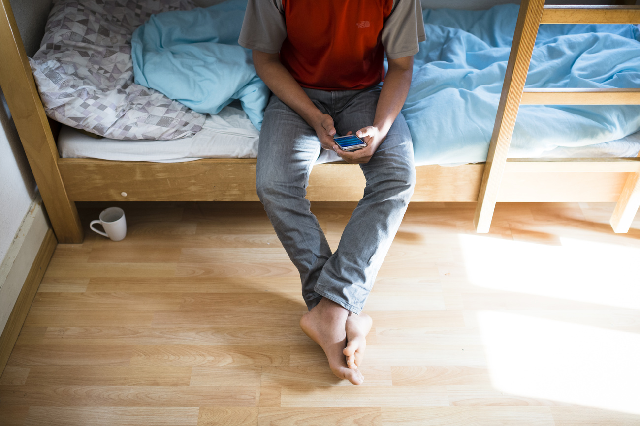 Man sitting on a bunk bed with mobile phone