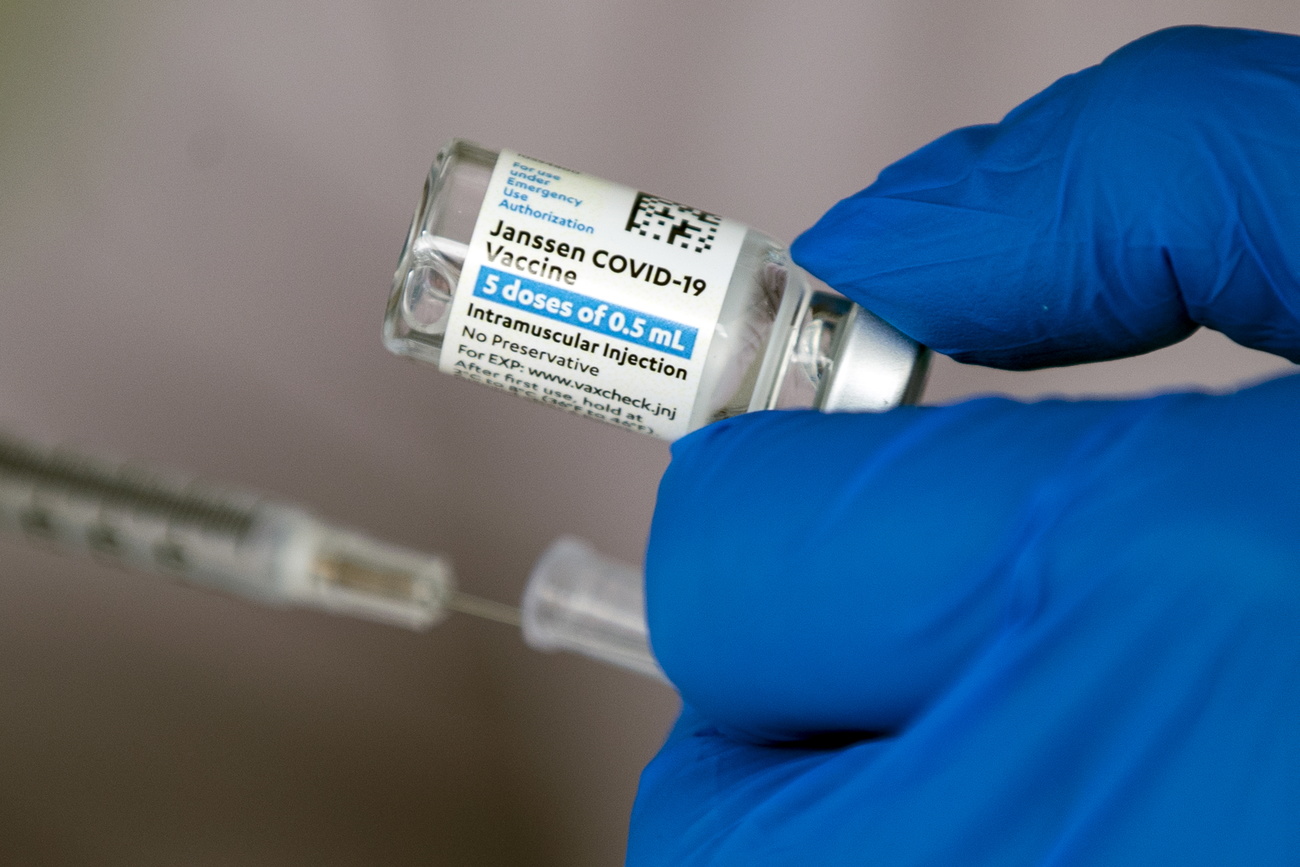Main gantée avec une fiole de vaccin
