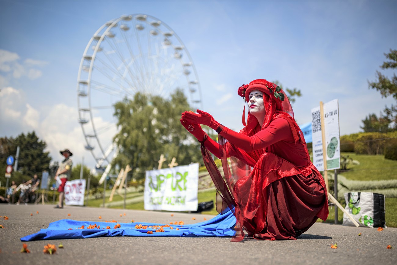 persona con un costume rosso e il volto dipinto di bianco e sullo sfondo una ruota panoramica