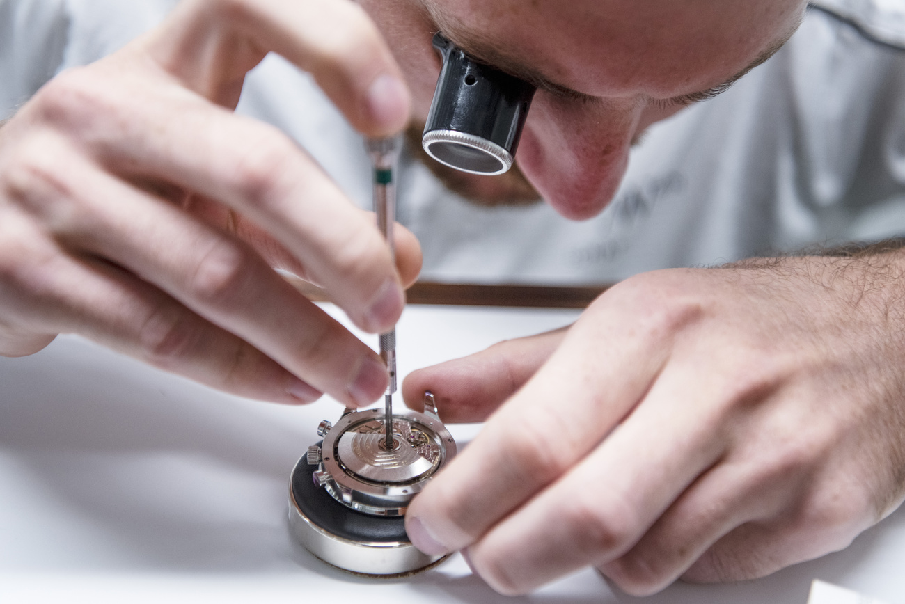 Un orologiaio che sta montando un orologio.