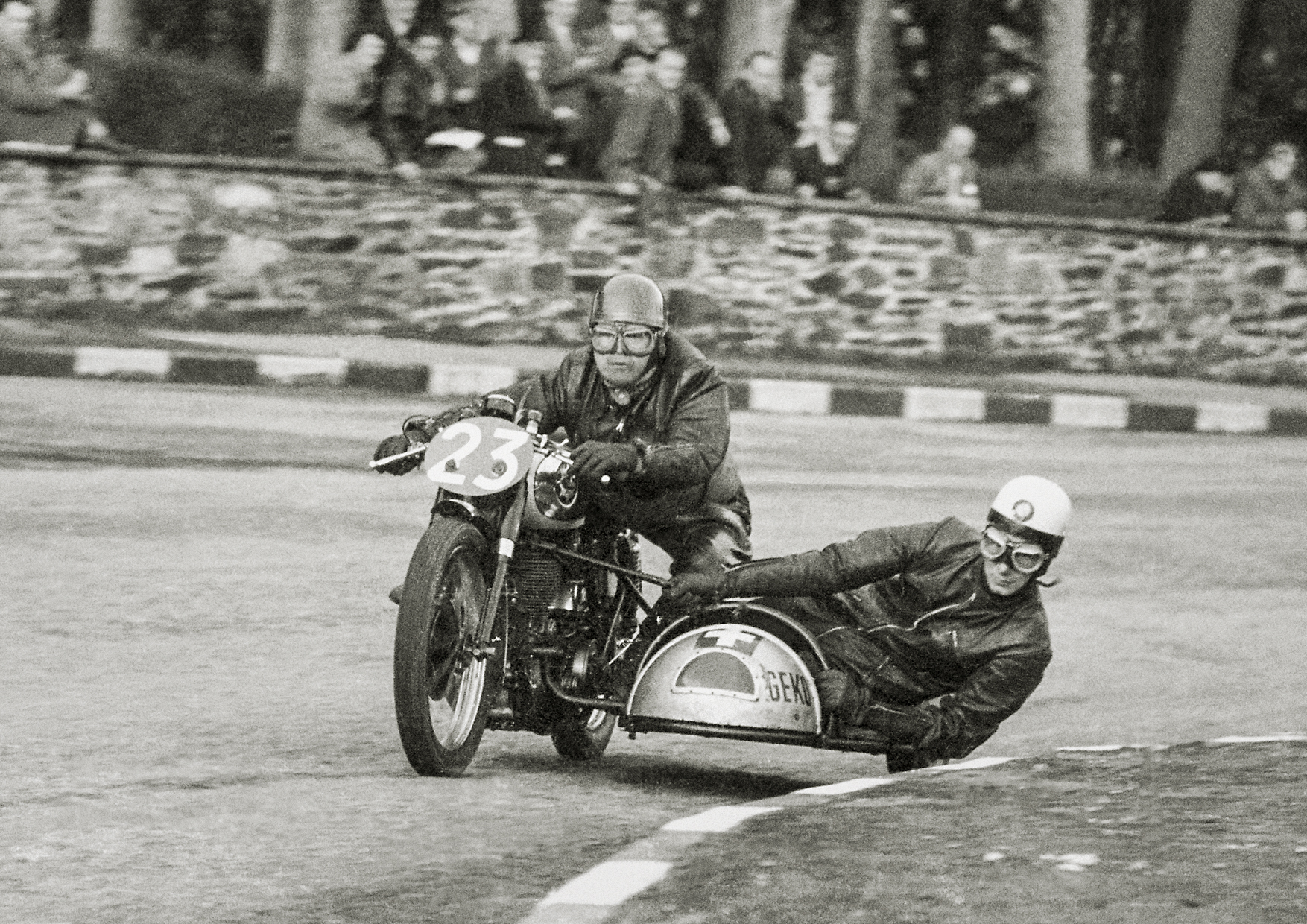 Dos hombres en una moto tipo side-car de carreras.