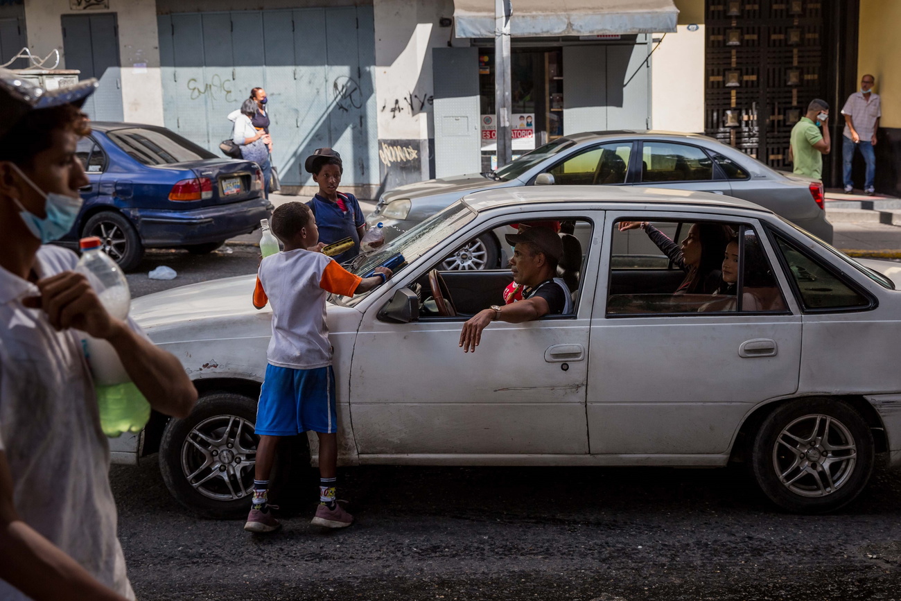 bambini puliscono aprabrezza di auto nel traffico