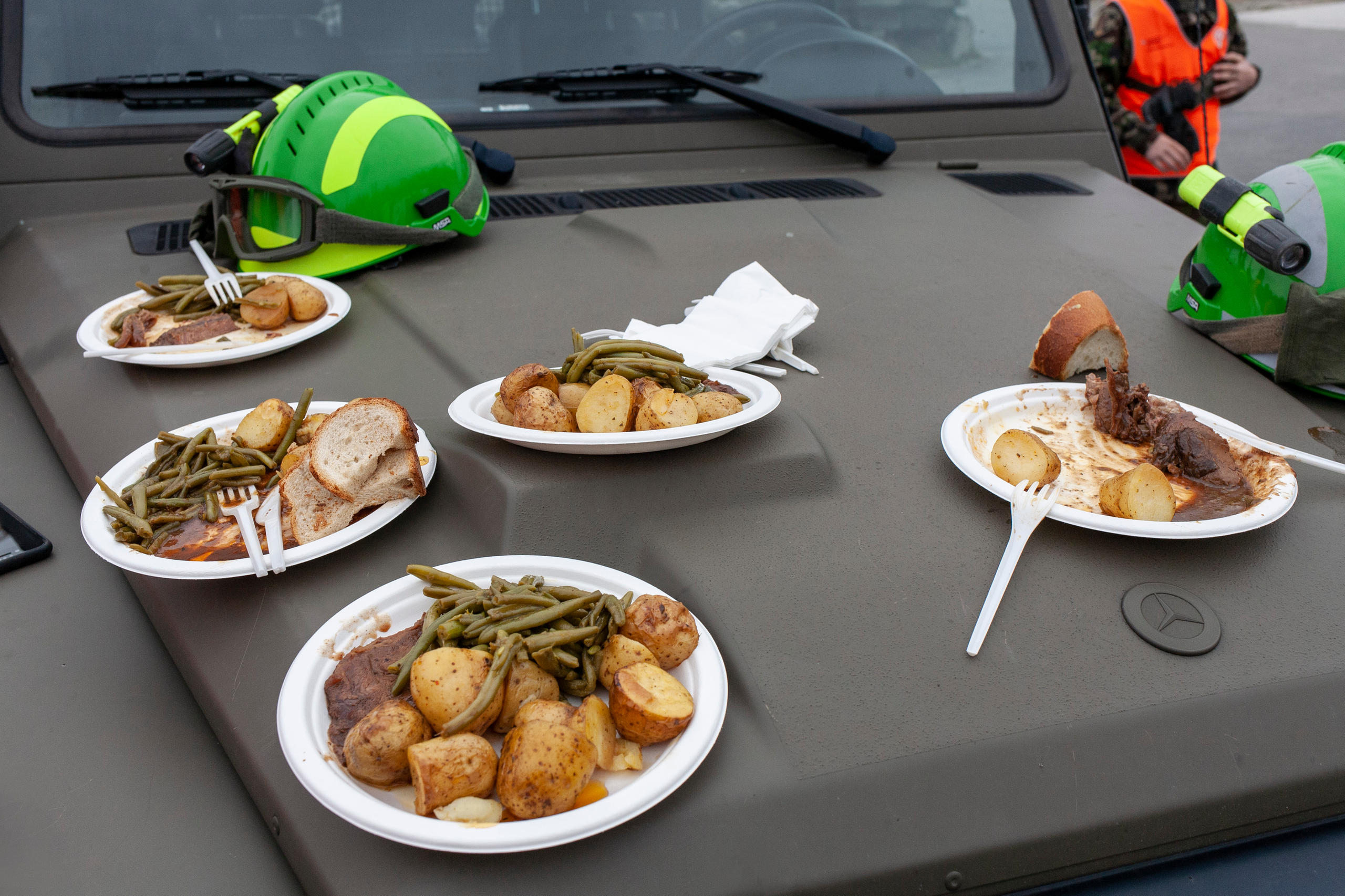 Vehículo del ejército haciendo de mesa con platos de comida encima