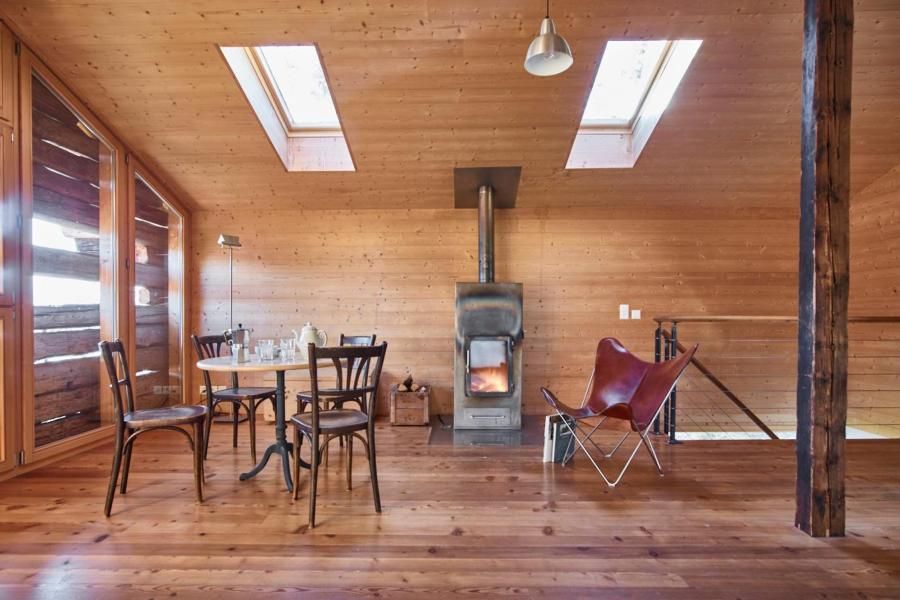 Pièce d intérieur tout en bois avec une table, des chaises et un poêle.