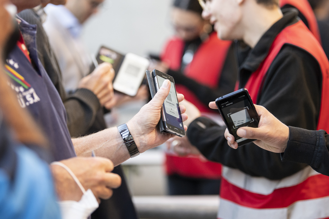 Diversas personas muestran su certificado COVID en su teléfono